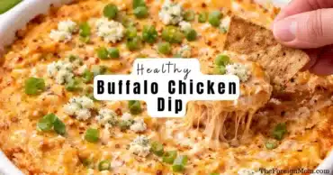 Hero image of healthy buffalo chicken dip baked until golden with melted cheese, green onions, and a cracker scooping the cheesy dip.