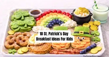 St. Patrick’s Day breakfast board with shamrock pancakes, rainbow fruit, leprechaun pancake, gold coin chocolates, and green milk for kids.
