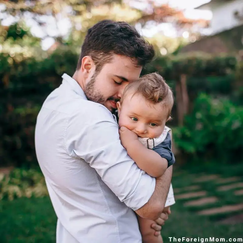 Dad holding and comforting his 8-month-old baby during a quiet outdoor moment