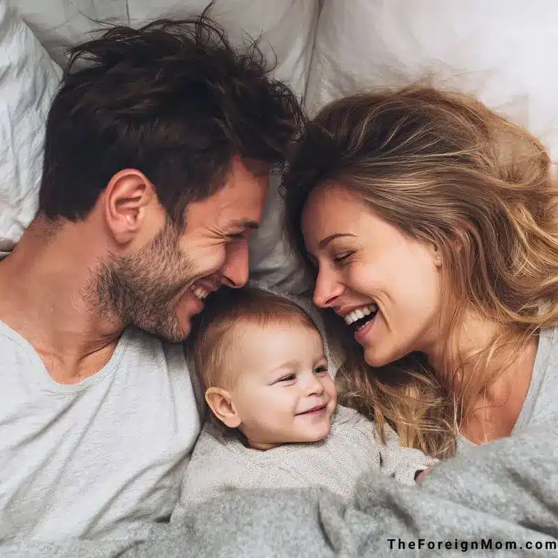Mom and dad lying together with their 8-month-old baby, sharing a quiet and loving family moment.
