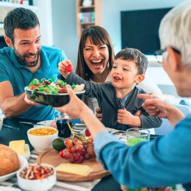 Family serving food at the table so mom can enjoy a meal she didn’t cook.