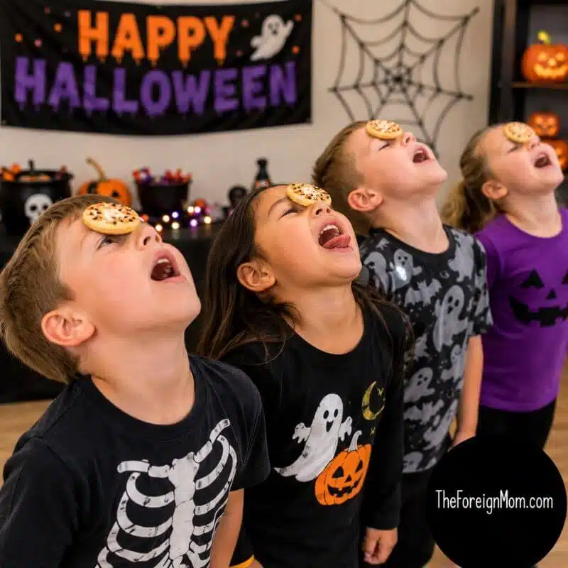 Kids playing the Halloween Cookie Face game by moving Halloween cookies from their foreheads to their mouths without using their hands.