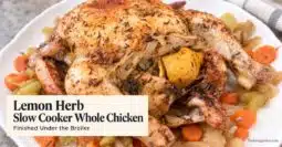 Lemon herb whole chicken with carrots, celery, and onions on a white platter, with text reading “Lemon Herb Slow Cooker Whole Chicken.”