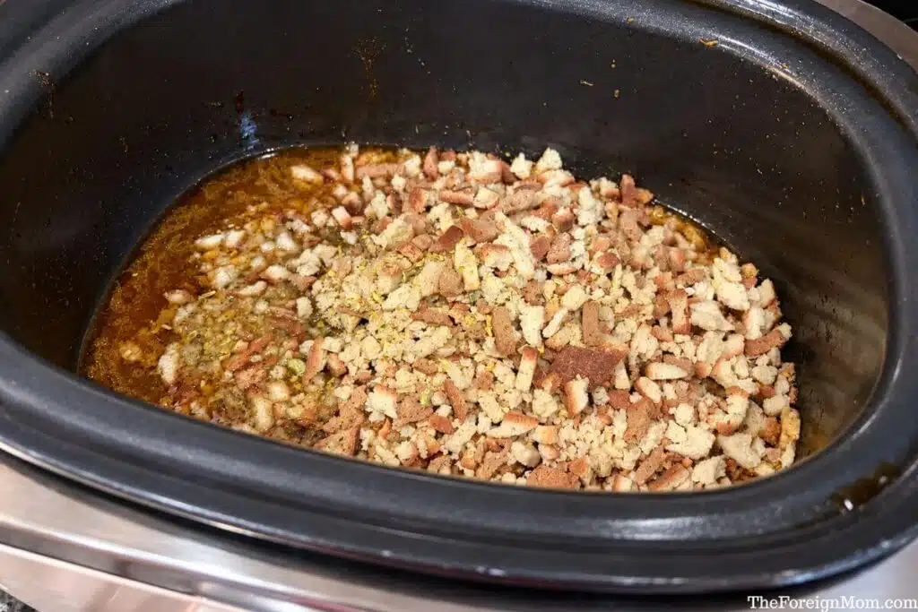 Dry stuffing mix added to chicken drippings and cooked vegetables in a slow cooker before stirring.