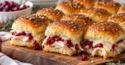 Thanksgiving leftover turkey cranberry sliders with cranberry sauce, melted Swiss cheese, and Hawaiian rolls.