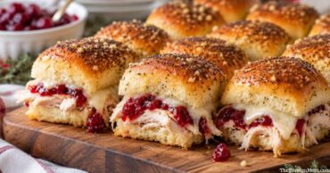 Thanksgiving leftover turkey cranberry sliders with cranberry sauce, melted Swiss cheese, and Hawaiian rolls.