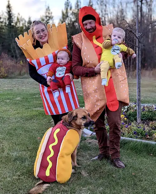 Babies in Ketchup and Mustard costume. Mother in French Fries costume and father and dog in hot dog costume.