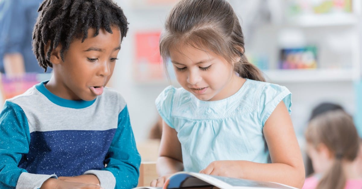 Boy and girl looking at book.